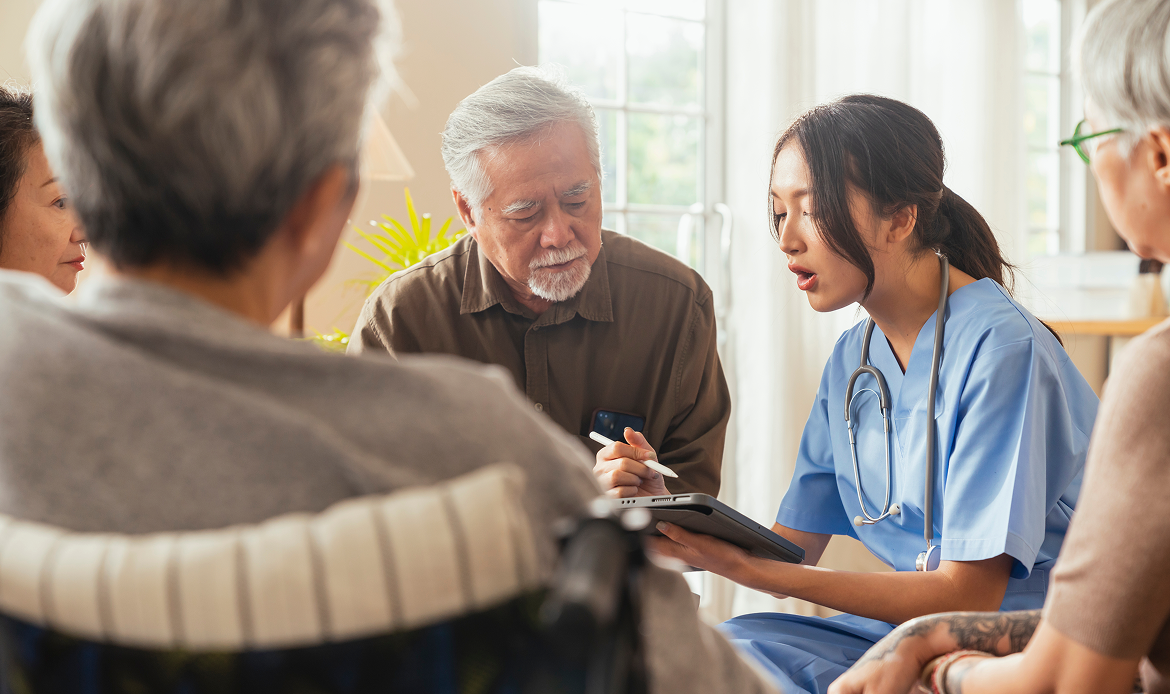 Healthcare staff member meeting with senior living residents to discuss foodservice operations and care planning