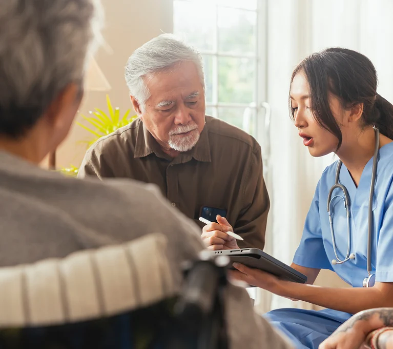 Healthcare staff member meeting with senior living residents to discuss foodservice operations and care planning